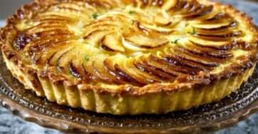 Tarte aux pommes avec crème pâtissière onctueuse, pommes en rosace légèrement caramélisées sur pâte croustillante dorée.