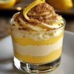 Verrines citron façon cheesecake avec couches de biscuits spéculoos, crème légère au fromage et citron, décorées de zestes.