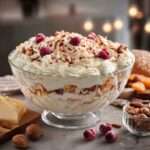 Trifle framboises en couches avec crème vanillée, biscuit moelleux, amandes croquantes et copeaux de chocolat blanc.