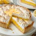 Tarte au citron meringuée maison avec crème citron lisse, meringue dorée et pâte sablée croustillante, présentée sur un plat élégant.