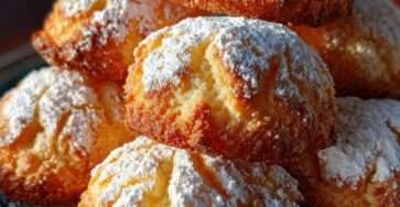 Muffins dorés et moelleux saupoudrés de sucre glace, avec une mie légère et aérée, disposés sur une grille après cuisson.