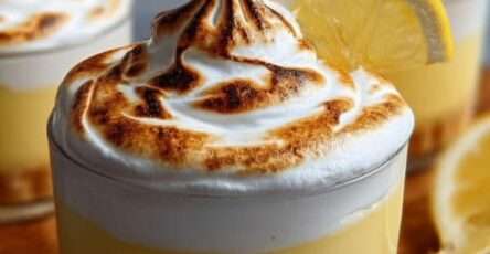Verrines citron avec base biscuitée, crème citron onctueuse et meringue dorée au chalumeau, présentées en portions individuelles élégantes.