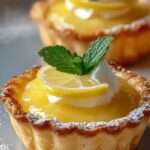 Tartelettes citron crémeuses avec pâte sablée dorée, garnies d’une crème citron lisse et brillante, décorées de chantilly et de zestes de citron frais.