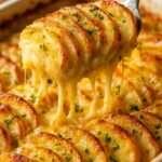 Gratin de pommes de terre au fromage ultra fondant servi chaud, avec couches crémeuses, fromage filant et croûte dorée croustillante.