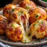 Bombes à pizza dorées au four avec cœur de mozzarella filante et pepperoni, surface croustillante au beurre et parmesan.