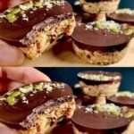 Barres énergétiques maison sans cuisson aux flocons d’avoine, dattes, graines et chocolat noir, découpées en portions régulières sur une surface en bois.