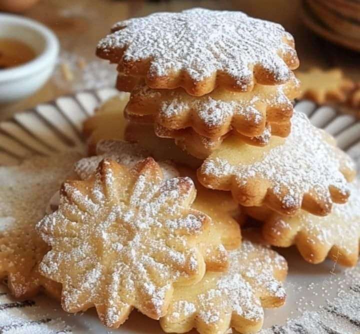Petits sablés maison dorés découpés en formes variées, légèrement saupoudrés de sucre glace, disposés sur une plaque avec une texture croustillante et fondante.