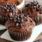Muffins au chocolat moelleux à la compote de pommes, texture légère et aérée, avec quelques pépites visibles, présentés sur une grille de refroidissement.