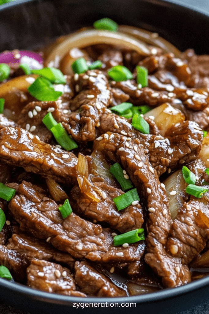 Assiette de sauté de bœuf aux oignons à la chinoise avec lamelles de viande brillantes, oignons légèrement caramélisés et sauce nappante, servie avec du riz blanc.