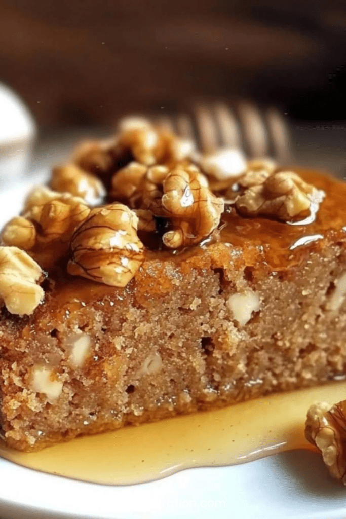 Gâteau aux noix et au miel doré, texture moelleuse avec morceaux de noix visibles, présenté en tranches sur un plat rustique.