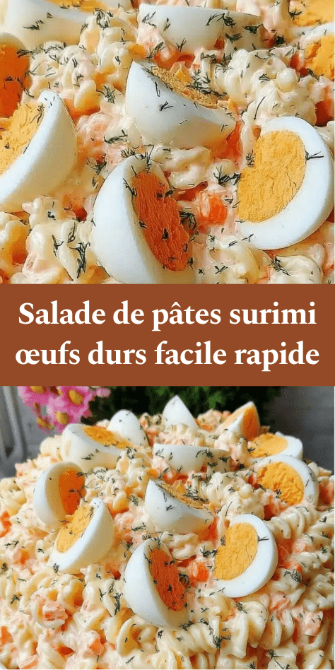 Salade de pâtes fusilli avec surimi, œufs durs, carottes et sauce crémeuse, garnie d’herbes fraîches dans un saladier.