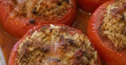 Tomates farcies maison gratinées au four avec viande hachée, riz et persil dans un plat familial rustique