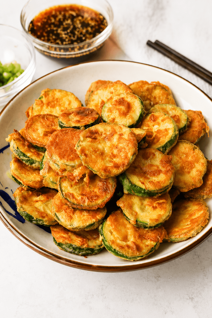 Beignets de courgettes croustillants servis chauds avec une sauce soja miel et graines de sésame.