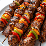 Brochettes de bœuf grillées avec poivrons rouges, jaunes et verts, oignons et marinade parfumée, servies avec du persil frais.