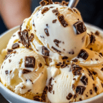Glace vanille maison aux pépites de chocolat, servie en boules dans une coupe avec morceaux de chocolat et texture crémeuse.