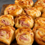 Croque-monsieur roulé au four façon apéro, petits roulés dorés au pain de mie, jambon et fromage fondant, servis chauds pour un apéritif gourmand.