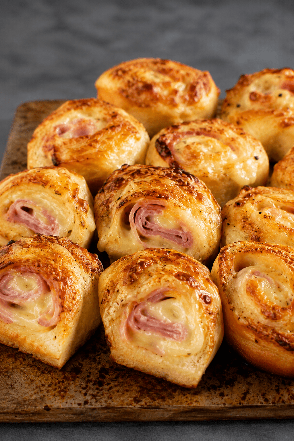 Croque-monsieur roulé au four façon apéro, petits roulés dorés au pain de mie, jambon et fromage fondant, servis chauds pour un apéritif gourmand.