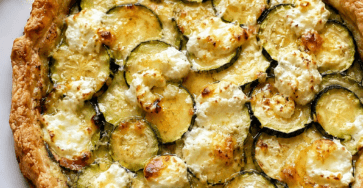 Tarte courgettes, chèvre et miel dorée au four, garnie de fines rondelles de courgettes, morceaux de fromage de chèvre fondant et filet de miel brillant.