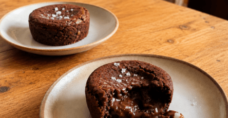 Fondant au chocolat noir servi tiède avec cœur coulant, filet d’huile d’olive douce et pincée de fleur de sel sur le dessus.