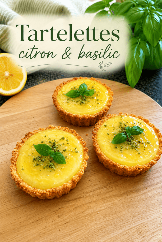 Mini tartelettes au citron maison garnies de crème citron brillante, d’un filet d’huile d’olive douce et de feuilles de basilic frais.
