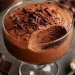 Verrines de mousse au chocolat noir intense, texture aérienne et fondante, décorées de copeaux de chocolat sur le dessus.