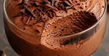 Verrines de mousse au chocolat noir intense, texture aérienne et fondante, décorées de copeaux de chocolat sur le dessus.