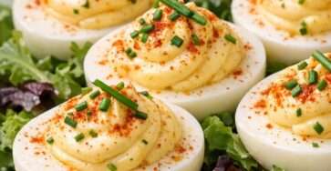 Œufs durs garnis à la mayonnaise citronnée, saupoudrés de paprika fumé et servis sur un lit de roquette fraîche.
