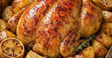 Poulet rôti entier à la peau dorée, servi avec pommes de terre fondantes, citron, ail, thym et jus de cuisson parfumé.