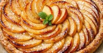Tarte aux pommes maison de grand-mère, garnie de fines lamelles de pommes dorées, sur une pâte croustillante et légèrement brillante.