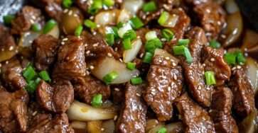 Sauté de bœuf aux oignons à la chinoise servi avec riz blanc, lamelles de bœuf tendres, sauce brillante, ail, oignons fondants et ciboule fraîche