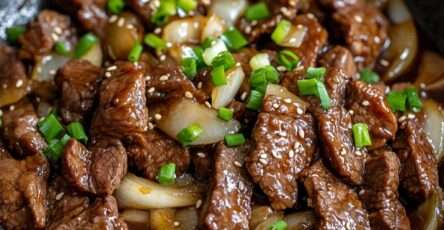 Sauté de bœuf aux oignons à la chinoise servi avec riz blanc, lamelles de bœuf tendres, sauce brillante, ail, oignons fondants et ciboule fraîche