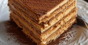 Gâteau Petit Beurre au café sans cuisson, composé de couches de biscuits imbibés de café et de crème au beurre cacao, servi en parts fondantes.