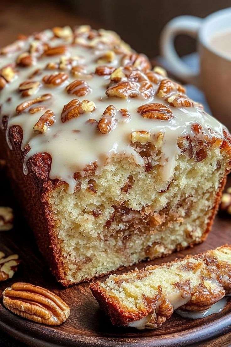 Cake moelleux aux noix de pécan avec cœur cannelle, nappé d’un glaçage vanillé et décoré de noix de pécan croquantes.