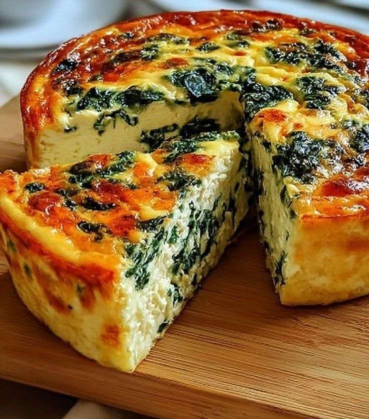Quiche épaisse aux épinards et fromage, dorée au four, servie en parts généreuses avec une texture fondante et une garniture verte.
