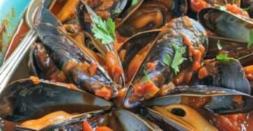 Moules fraîches à la sauce tomate épicée avec ail, oignon, paprika, vin blanc, piment, persil frais et sauce rouge parfumée.