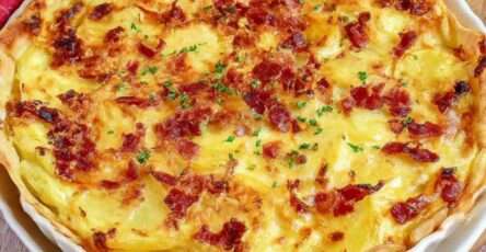 Tarte salée aux pommes de terre fondantes, lardons fumés dorés, crème fraîche, œufs et comté râpé gratiné sur pâte brisée.