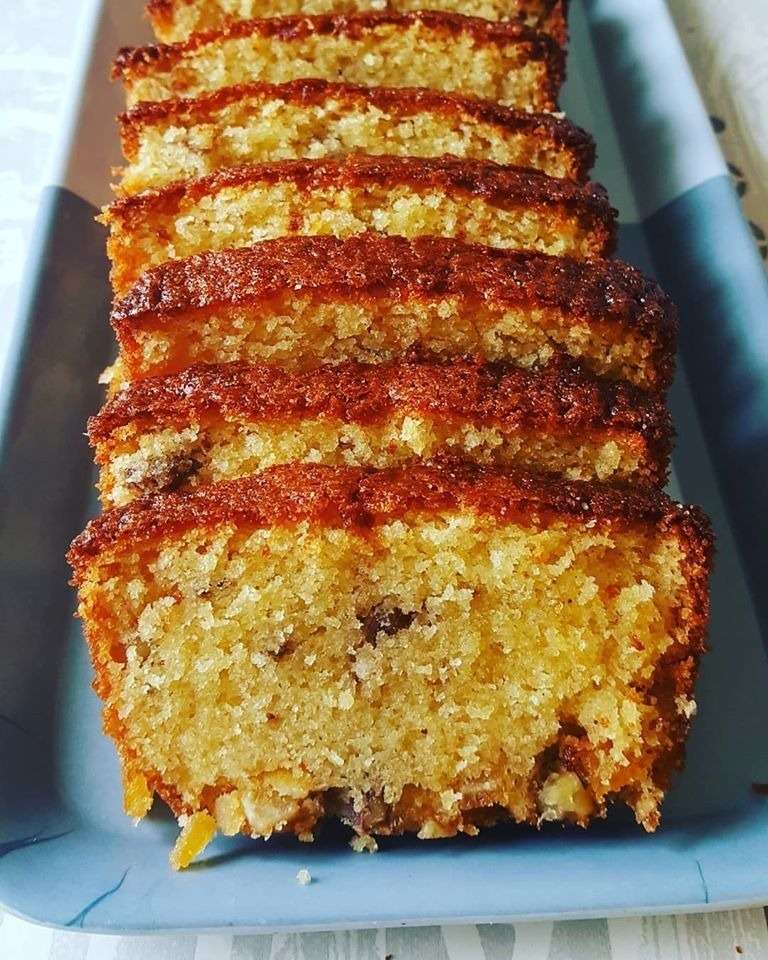 Cake à l’orange, miel et noix coupé en tranches, moelleux et doré, servi avec un sirop parfumé à l’orange.