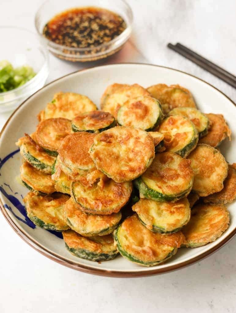 Beignets de courgettes croustillants servis chauds avec une sauce soja miel et graines de sésame.