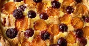 Tarte abricots et cerises dorée et gourmande maison avec crème vanillée dans un moule rustique en été