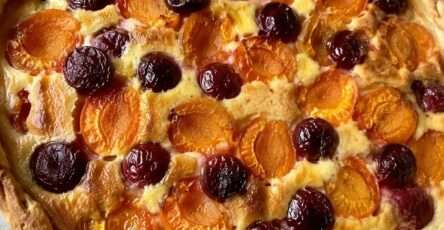 Tarte abricots et cerises dorée et gourmande maison avec crème vanillée dans un moule rustique en été