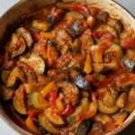 Ratatouille maison aux tomates, courgettes, aubergines et poivrons mijotés dans une cocotte rustique