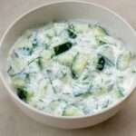 Salade concombre au yaourt avec menthe, citron et herbes servie dans un bol estival rafraîchissant