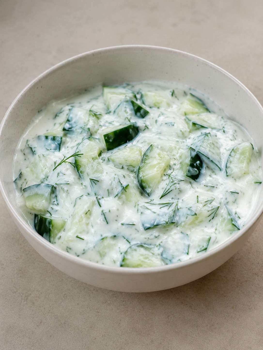 Salade concombre au yaourt avec menthe, citron et herbes servie dans un bol estival rafraîchissant