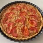 Tarte thon salée, tomates et moutarde avec fromage gratiné dans un moule rustique doré au four