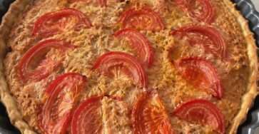Tarte thon salée, tomates et moutarde avec fromage gratiné dans un moule rustique doré au four