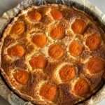 Tarte amandine aux abricots dorée avec crème aux amandes fondante et abricots caramélisés dans un moule rustique