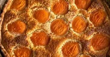 Tarte amandine aux abricots dorée avec crème aux amandes fondante et abricots caramélisés dans un moule rustique