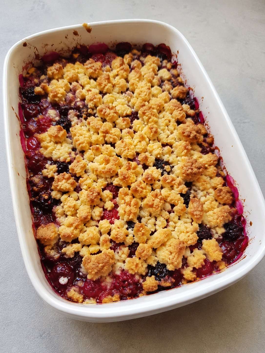Crumble maison aux fruits rouges avec pâte croustillante dorée et fruits fondants servis dans un plat rustique