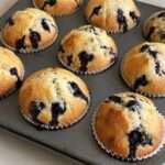 Muffins maison aux myrtilles moelleux et dorés servis sur une table avec quelques myrtilles fraîches
