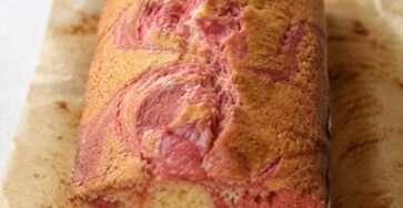 Cake marbré vanille-fraise moelleux avec spirales roses et vanillées dans un moule à cake maison gourmand